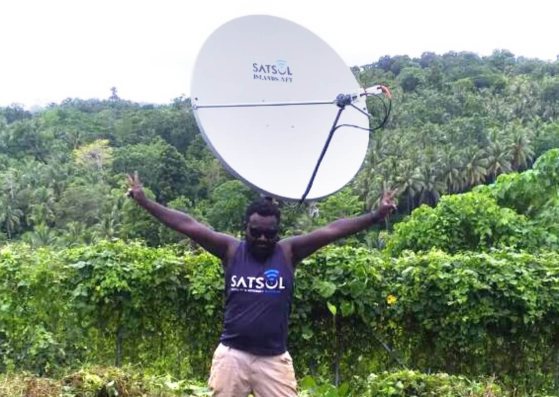 A man with a satelite receiver to connect from remote location in Solomon Islands